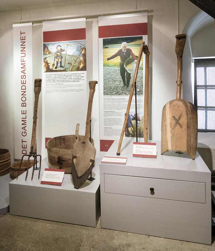 Bildet viser gjenstander utstilt i utstillingen. Det er en sliul, en spade og høygaffel.