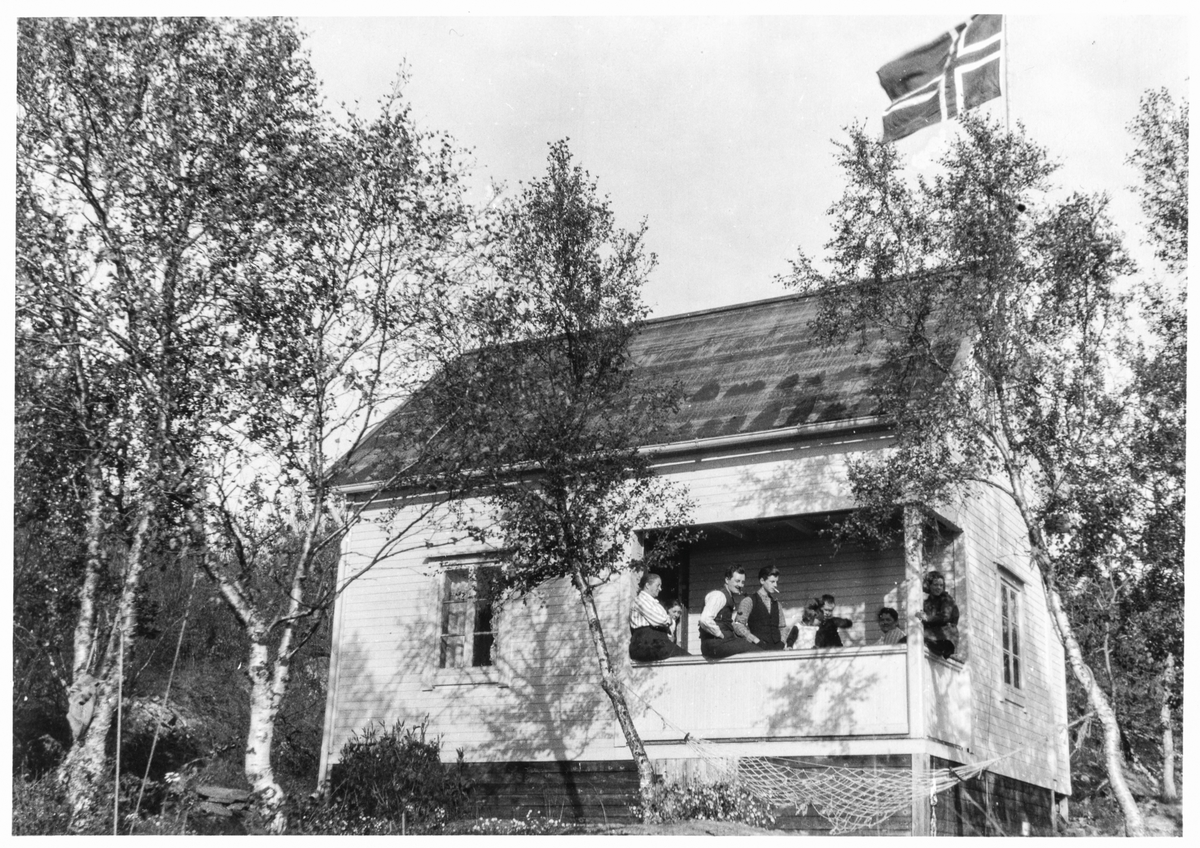 Familie på verandaen til et hus eller en hytte i Kanebogen.