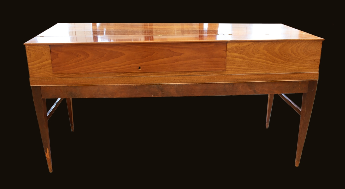 Hammarklaver i trä med svarta tangenter. Klaveret är delbart, med en bordsdel placerat löst på en ram med fyra kvadratiska avsmalnande ben.

Dekoren ovanför tangenterna är av ljusare trä inramat med en bård med intarsia i ljusare och mörkare trä. Enligt Benjamin Vogels inventering "Kulturhistoriska museets pianosamling, STM 1994-95", är detta typiskt engelskt. I mitten på namnbrädet finns inskriptionen "Delectamentum Aurium & Animi" Runt om  inskriptionen finns dekor av växtslingor i intarsia.

I instrumentets insida finns en springa i resonansbotten som lär vara speciell för dessa instrument, enligt Benjamin Vogel, som gör att dateringen kan vara runt sekelskiftet 17-1800.