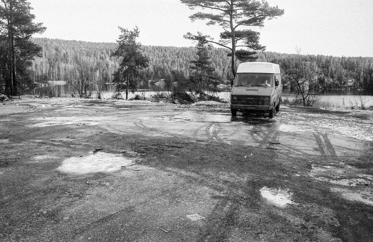 Bildumping i Gjersjøen. Snø og slaps. Bilvrak blir dratt opp med kranbil på lasteplan. Gjersjøen i bakgrunnen.