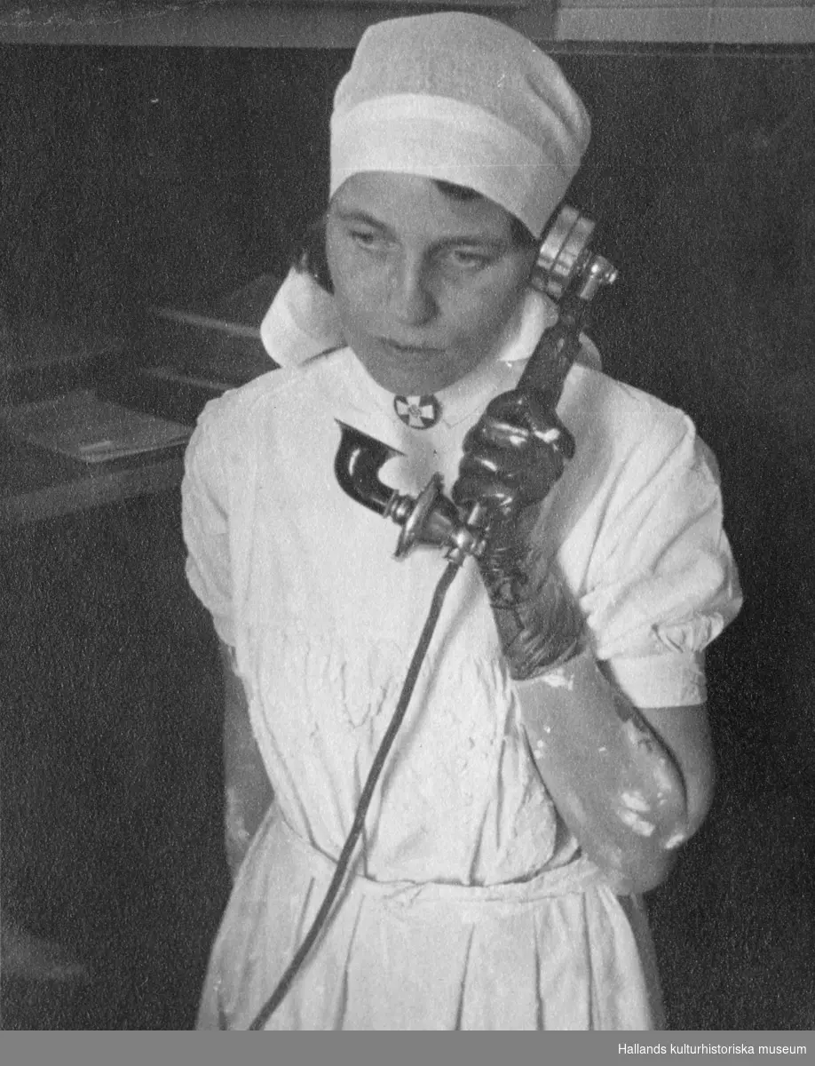 En sköterska på gipsavdelningen på Kustsanatoriet Apelviken talar i telefon. På arm och hand syns gipsrester.