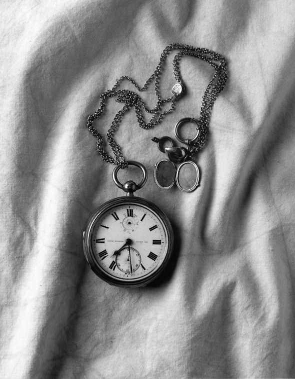 S A Andrées kronometer i kedja med berlock som innehåller fotografi på hans mamma och pappa. Återfanns på Vitön 1930.