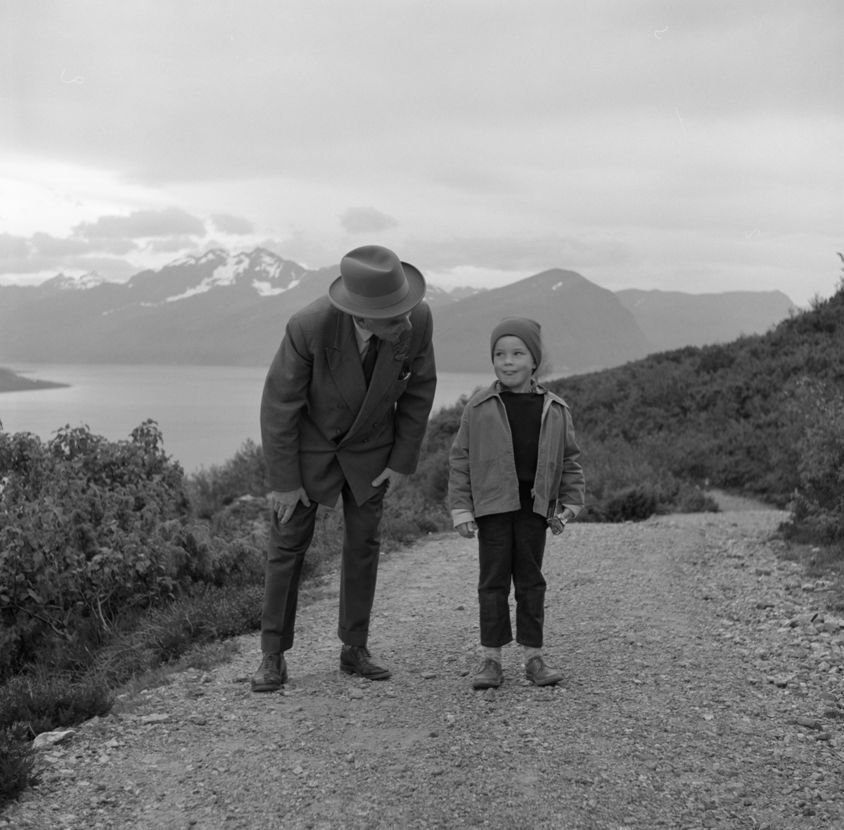 En bildeserie av en mann og en gutt på spasertur langs en vei.
