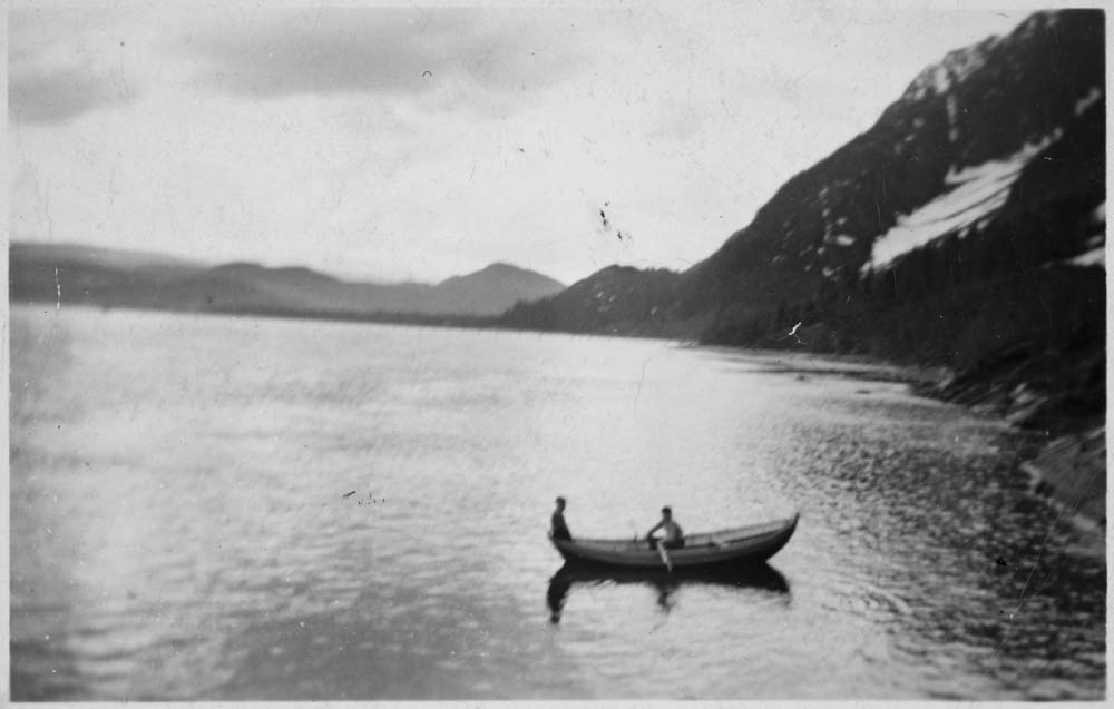 To personer i en robåt i Vefsna. Øyfjellet til høyre.