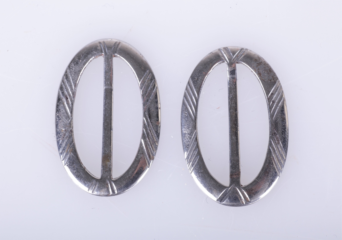 To ovale sølvspenner.