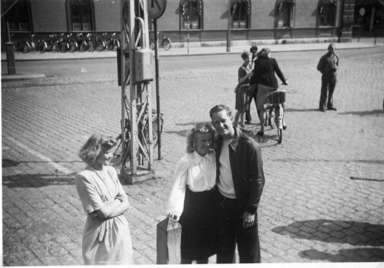 En man i skinnjacka står på plan utanför Stora Hotellet i Jönköping och kramar en kvinna. En annan kvinna står intill och tittar på.