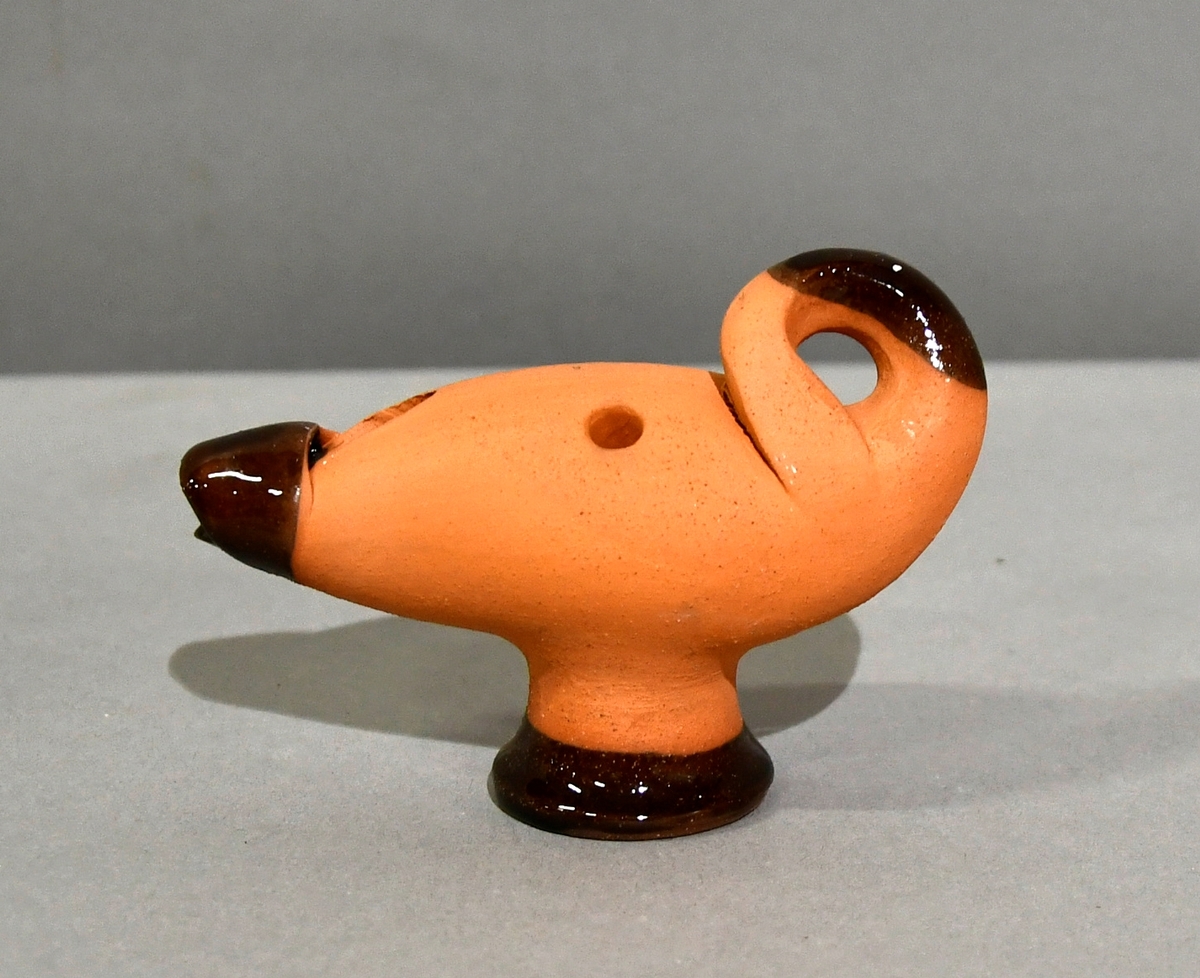 Leirgauk av keramikk formet som en svane som har lagt hodet under vingen.