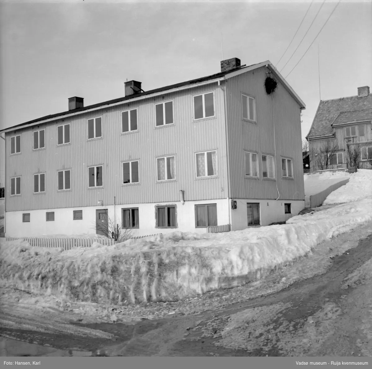 Eldrehjemmet Alders hvile i Vadsø, krysset Nyborgveien 35 -Esbensensgate,  vinteren 1964. Bygget er oppført tidlig 50-tall og har senere  vært benyttet bla til elevboliger, husmorskole, leiligheter for flyktninger. 