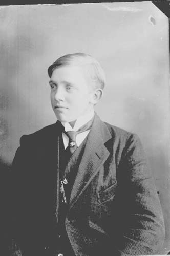 Algot Larsson, en ung man i kostym, väst, kravatt och klockkedja.