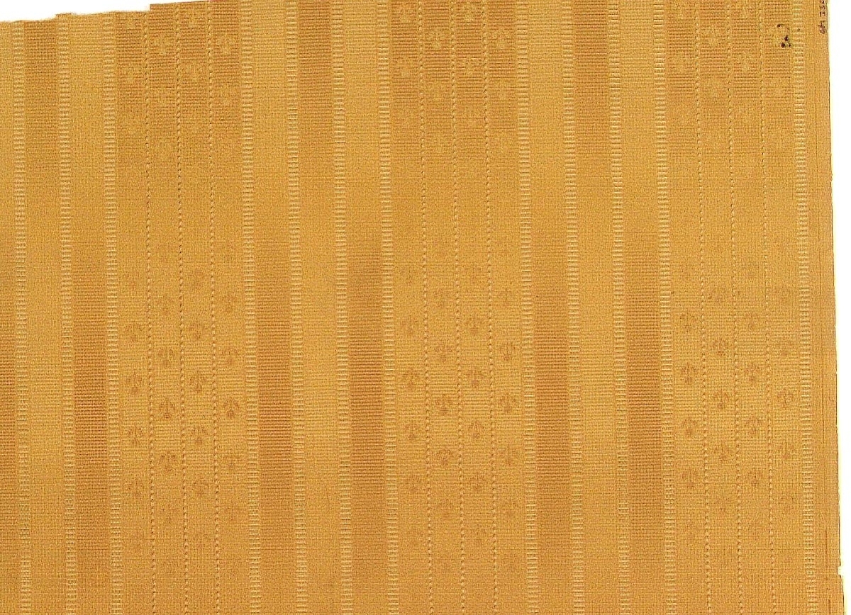 Vertikalt randmönster i vitt och något brunt på ett orange genomfärgat papper. Textilimiterande.