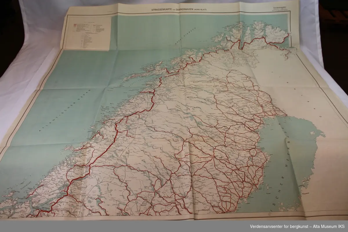 5 gule mapper med innhold og et kartblad over Norge nord for Dovre.