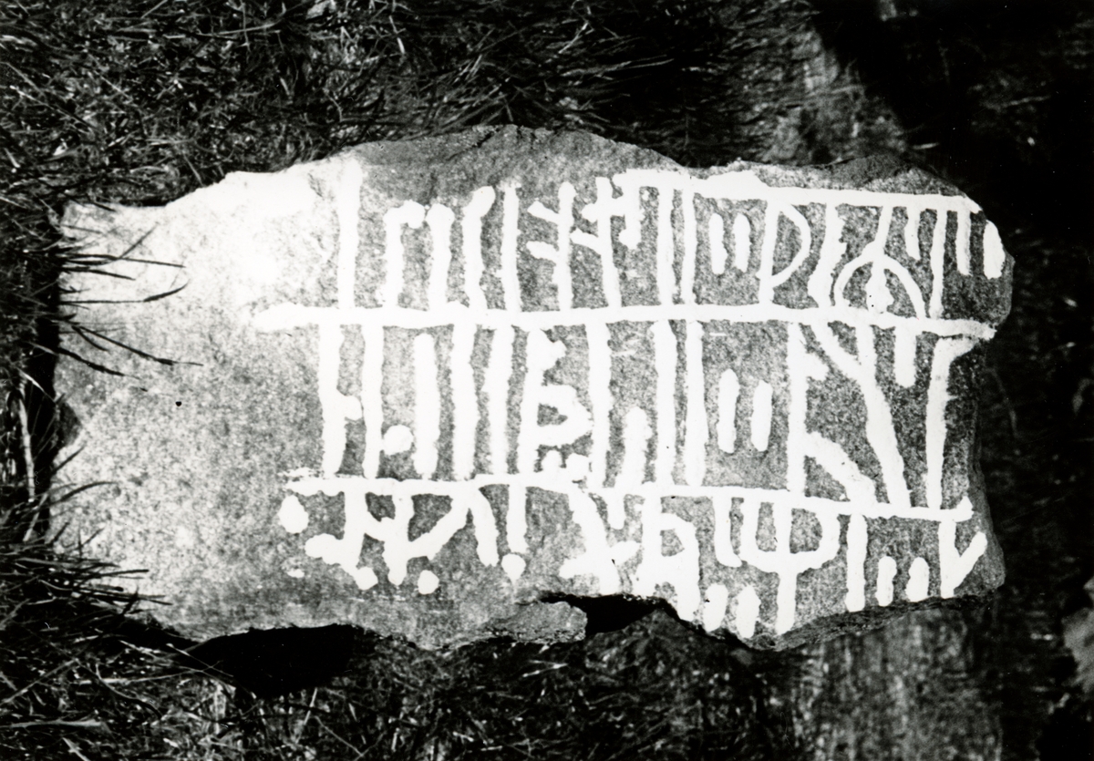 Enligt text: "Runstensfragment. "Tossenestenen". Fyndplats: Överby, Tossene. Runstenen grävdes ursprungligen fram i en gravhög på hemmanet Valla. Högen jämnades med marken".