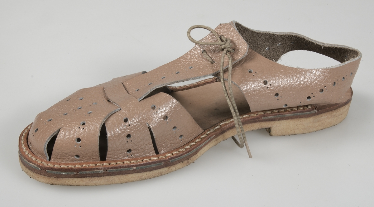 Sandal av ljusbrunt perforerat skinn, sandalsydd konstlädersula med pålimmad konstlädersula, mittslejf som snöres mot vristslejfen.