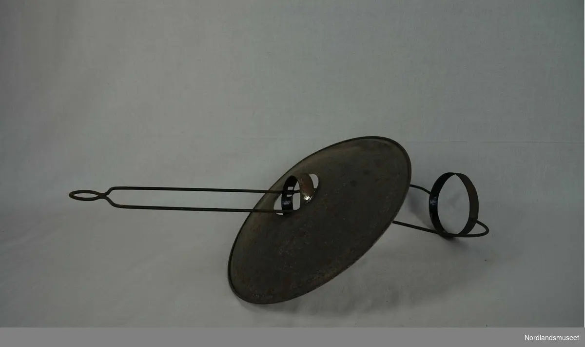 Form: Oval Brukt til oppheng av parafinlampe, en billig og tradisjonell form. Skjermen er rund og tredd på en metallbøyle som har en ring nede til å sette lampen i og en ring oppe til å henge skjermen på. En liten bøyle oppe til å henge lampen i taket. Behandlet med dip sept.1990.
