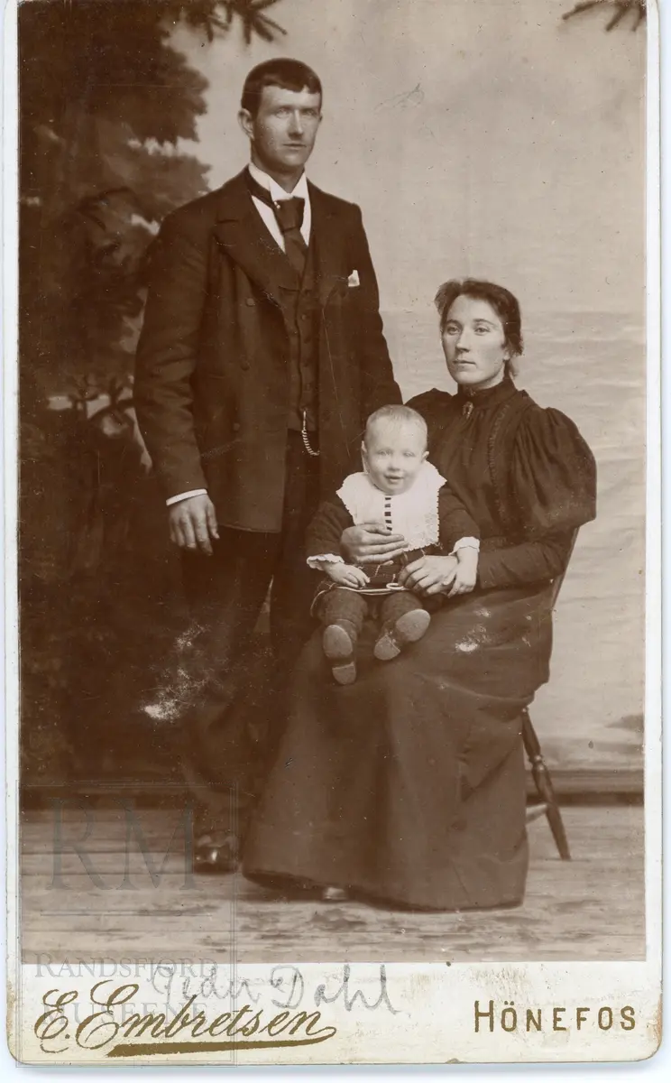 Familiegruppe, mann og kone med et barn på fanget. På bildet er notert Peder Dahl.