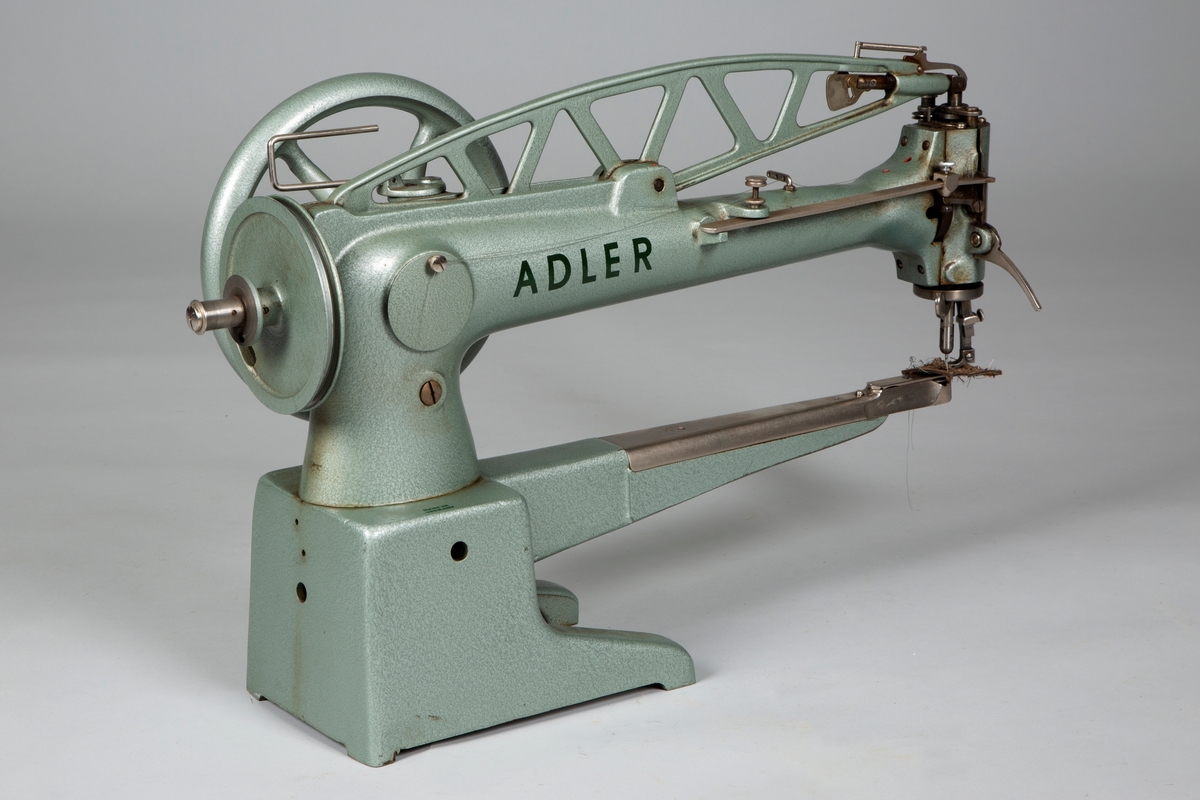 Skomakersymaskin, type Adler med stativ

Stativet er utført i metall, samme grønnfarge som maskinen.  Har innebygd støtte for beina. 
Høyde: 67 cm
Bredde: 50 cm
Lengden: 84 cm