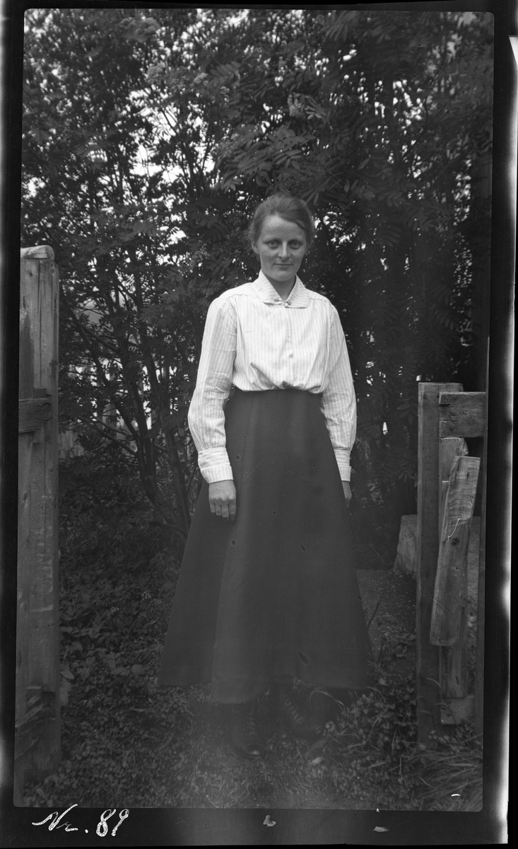 Portrett av en ung kvinne stående i en portåpning.