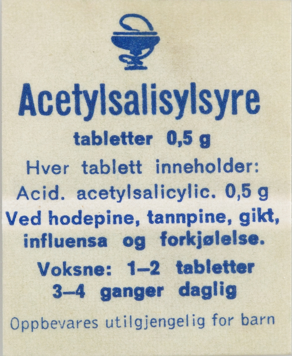 Selvklebende etikett til preparat til innvortes bruk. Dekorert med emblemet til Norges Apotekerforening. Baksiden av etikettene er forsynt med pergamentpapir som beskytter limflaten.