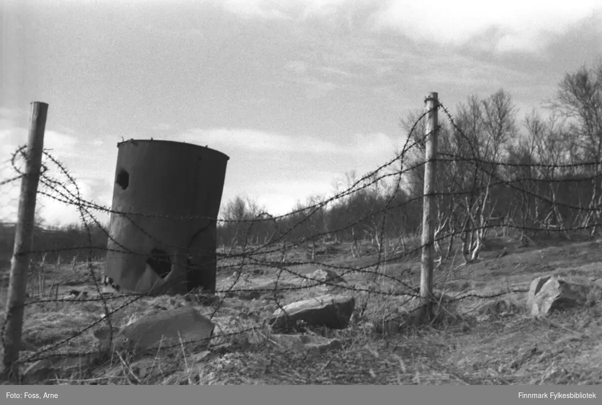 Piggtrådgjerde og rusten tønne, fra veien mellom Rustefjelbma og Smalfjord, i mai 1946.