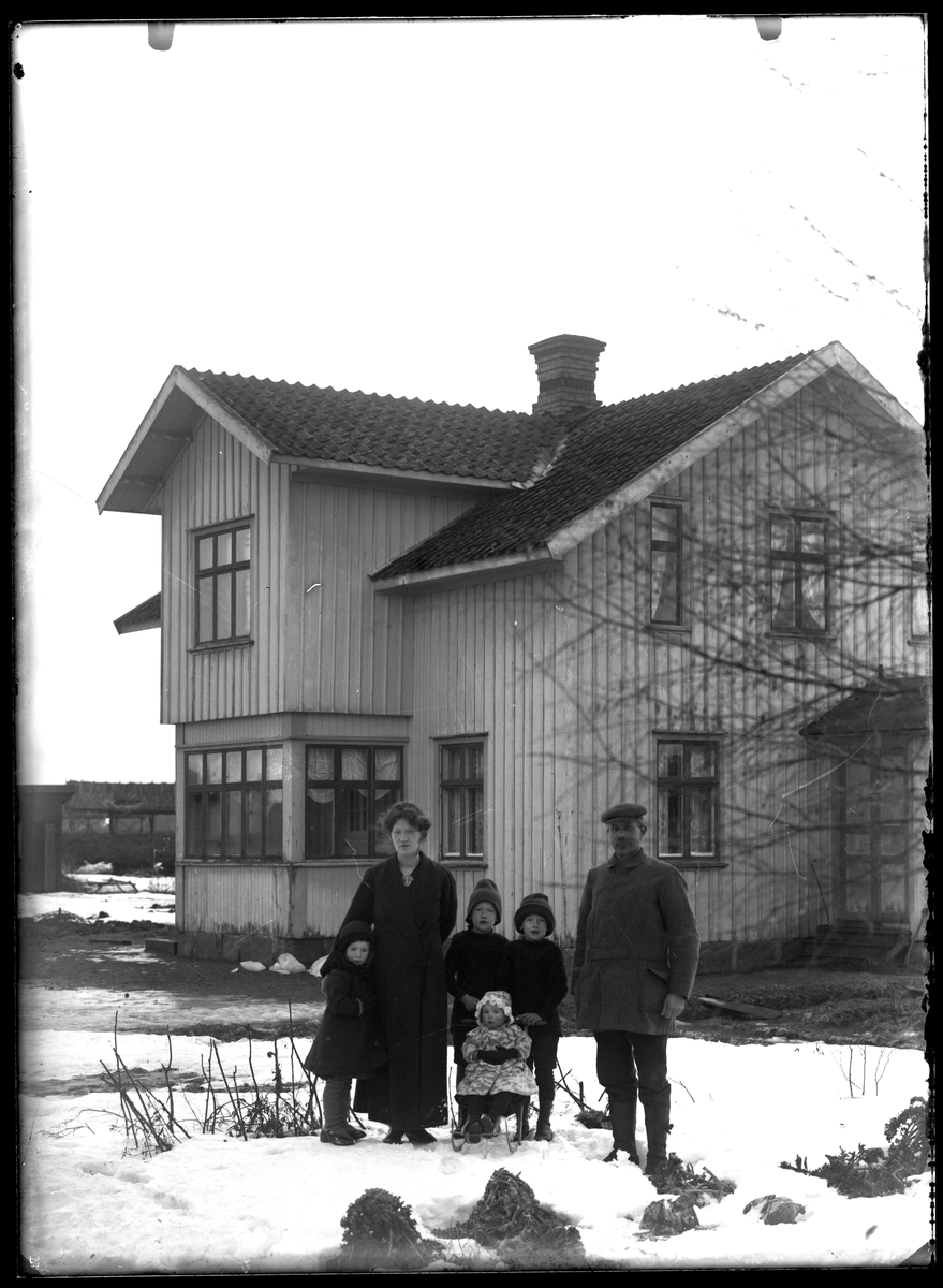 Stor familj framför bostadshus