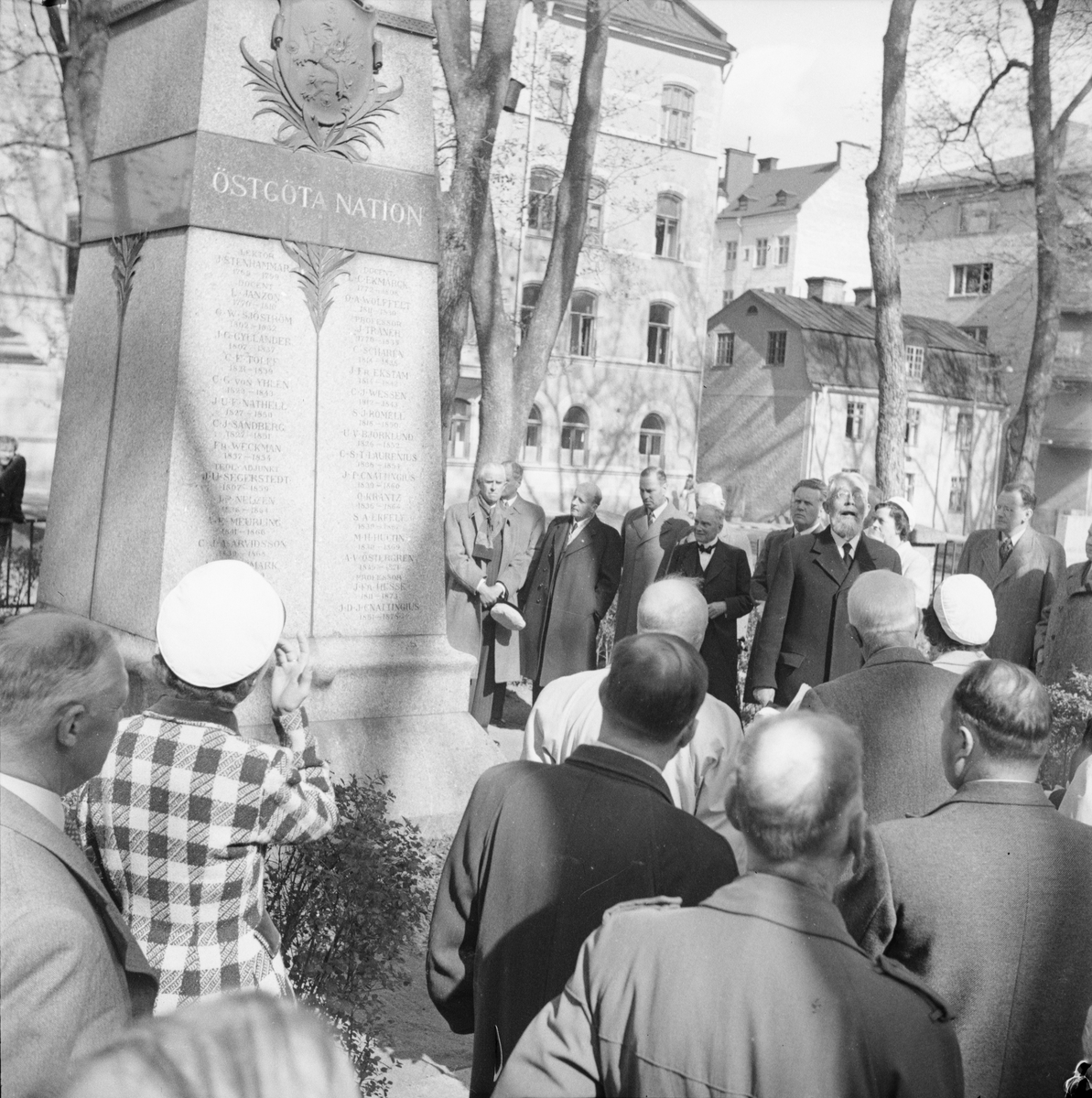 Män och kvinnor med studentmössor besöker Östgöta nationsgrav, Östgöta nations minneslandskap, Uppsala gamla kyrkogård, Uppsala 1949