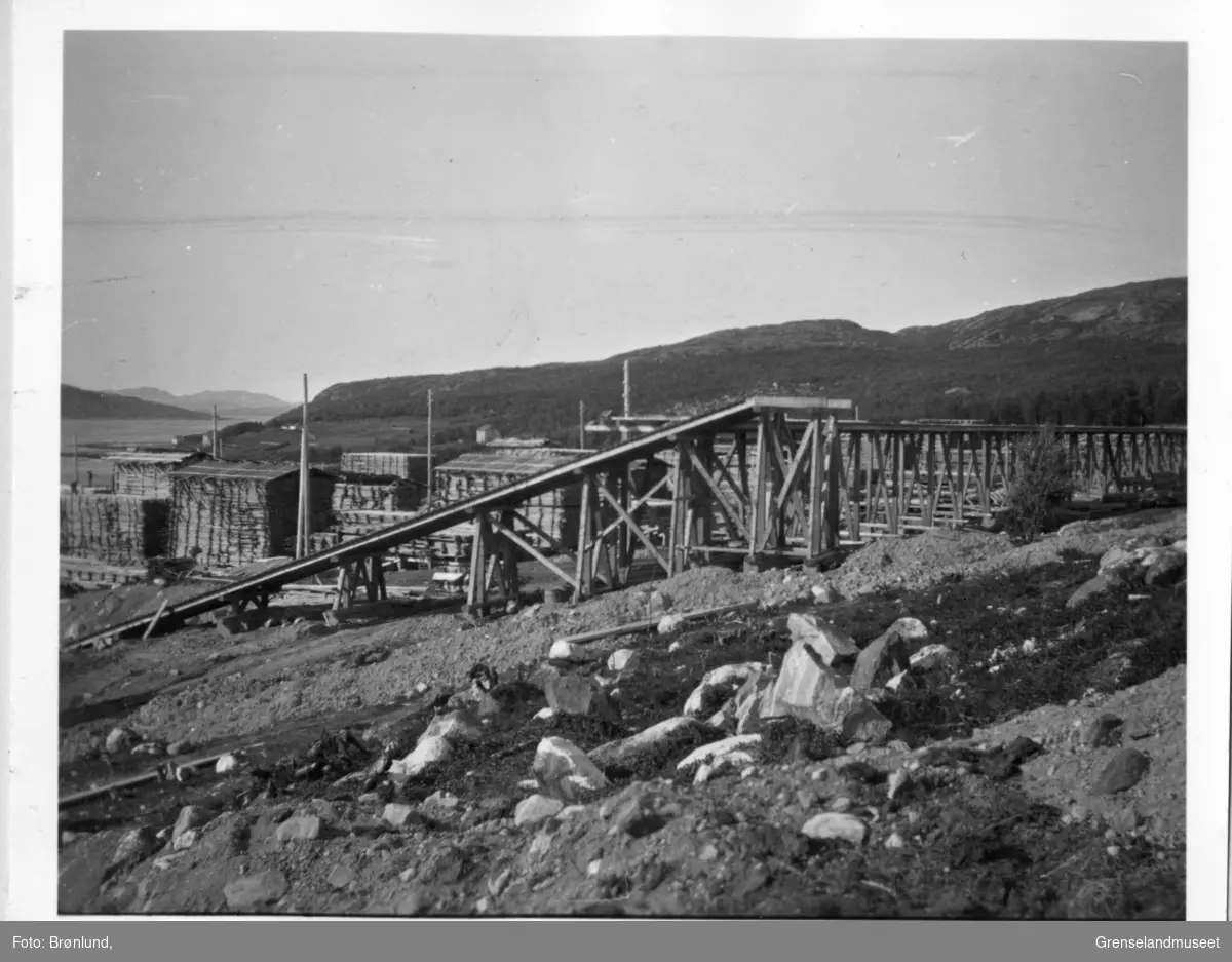 Pasvik Timber sitt anlegg på Jakobsnes før 1940, sett ut mot Bøkfjorden. Kjerraten midt i bildet med plankestabler i bakgrunnen. 