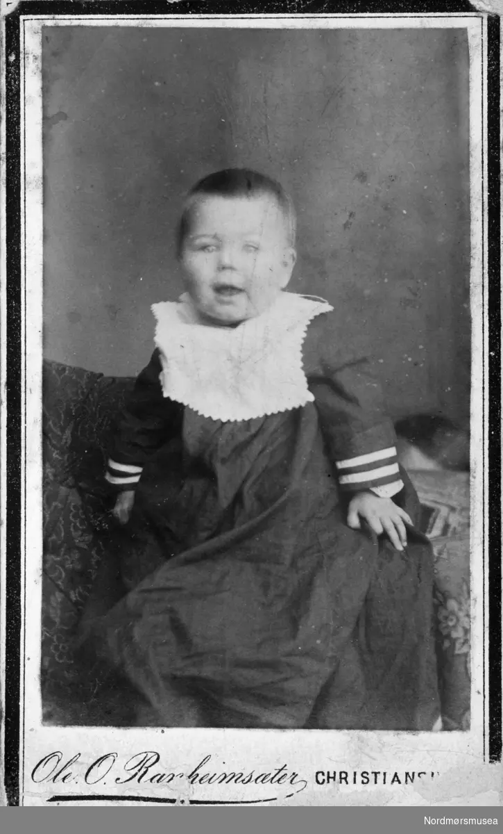 Portrettfoto av et ukjent barn. Trolig fra Kristiansund, siden det er der hvedkommende er fotografert. Det er Ole O. Ranheimsæter som er fotograf. Bildet kan trolig dateres til omkring 1880-1900. Fra Nordmøre museums fotosamlinger.
