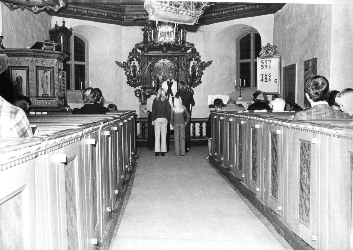 Några ungdomar står framför prästen vid altaret i Kållereds kyrka (Svenska kyrkan) innan 1976.