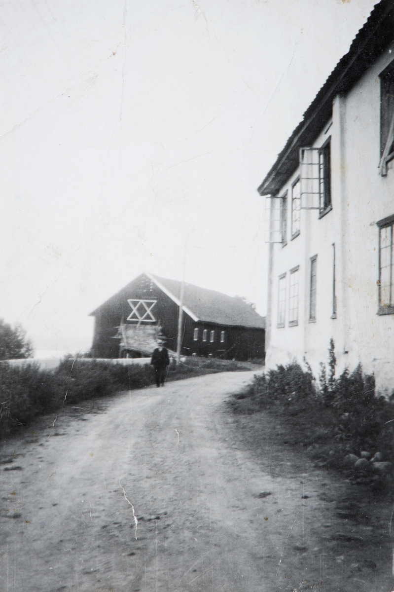 Gammel hovedbygning på Nedre Avlangerud, Helgøya som lå helt inntil bygdevegen. Den gamle låven i bakgrunn.
