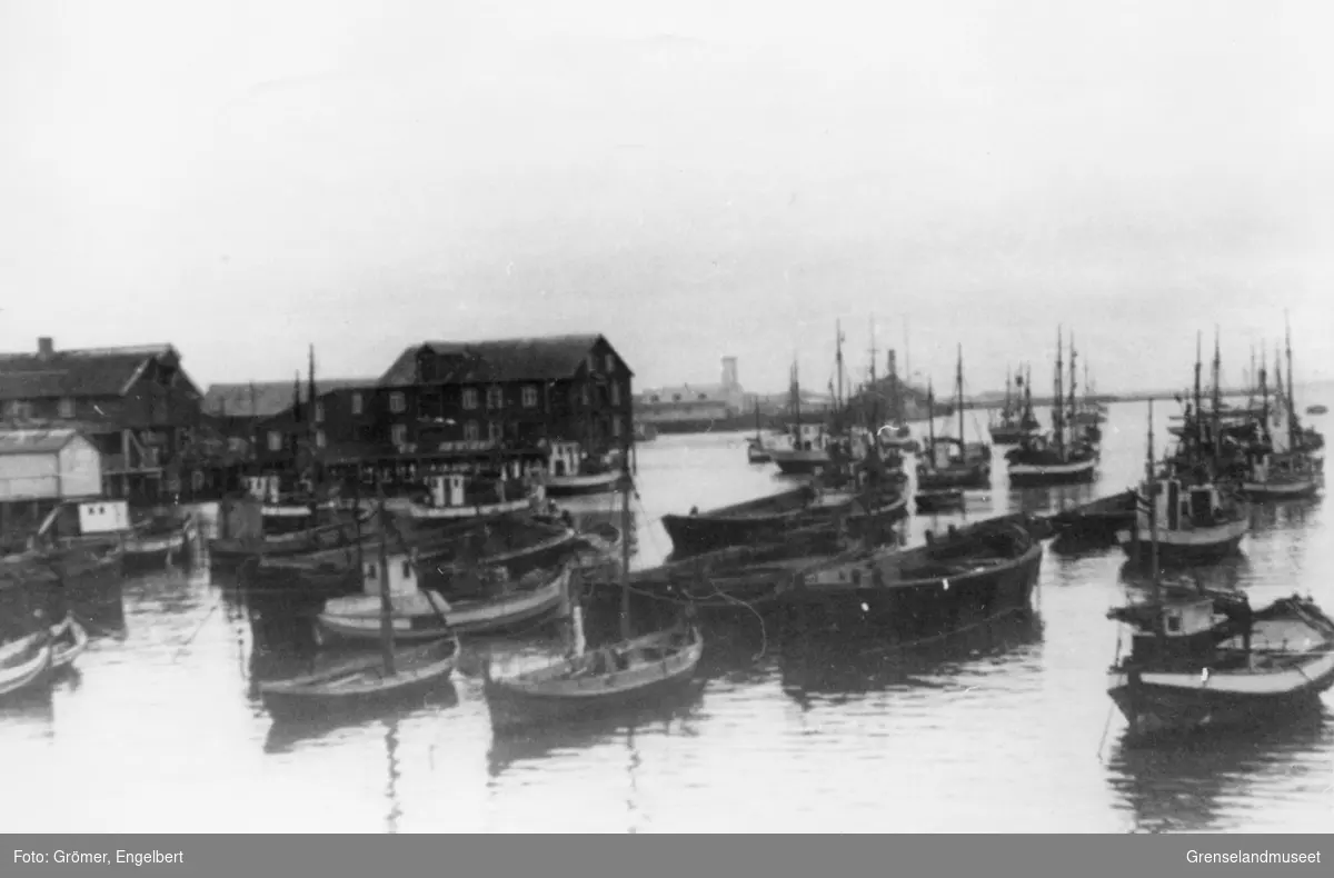 Bilde fra et havneområde med blant annet fiskebåter, med og uten motor.