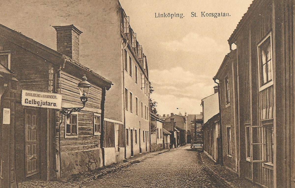 Vykort Bild från parti av Sankt Korsgatan i Linköping 
Drottninggatan, S:t Korsgatan, Gelbgjuteri,
Poststämplat 22 december 1921
Calegi vykortslager Stockholm