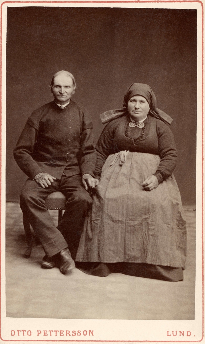 Ett par poserar för fotografen klädd i tidstypiska kläder