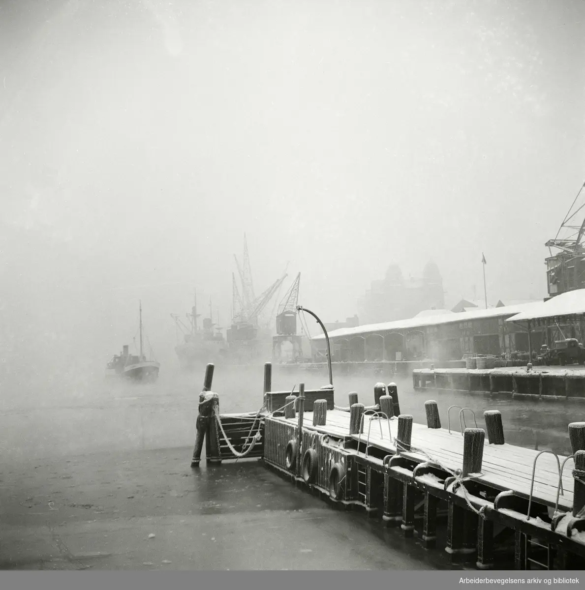 Vinter på havna i Oslo. Oslo Havnelager skimtes i bakgrunnen. Mars 1954.