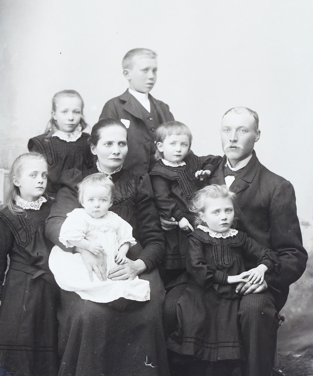 Gruppeportrett av en familie, to voksne og seks barn.