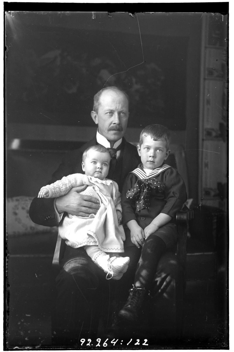 Hålahult sanatorium, interiör, en man i kostym sittande med två barn i knät, samma pojke som bild nr LTM-92-264-121, LTM-92-264-123