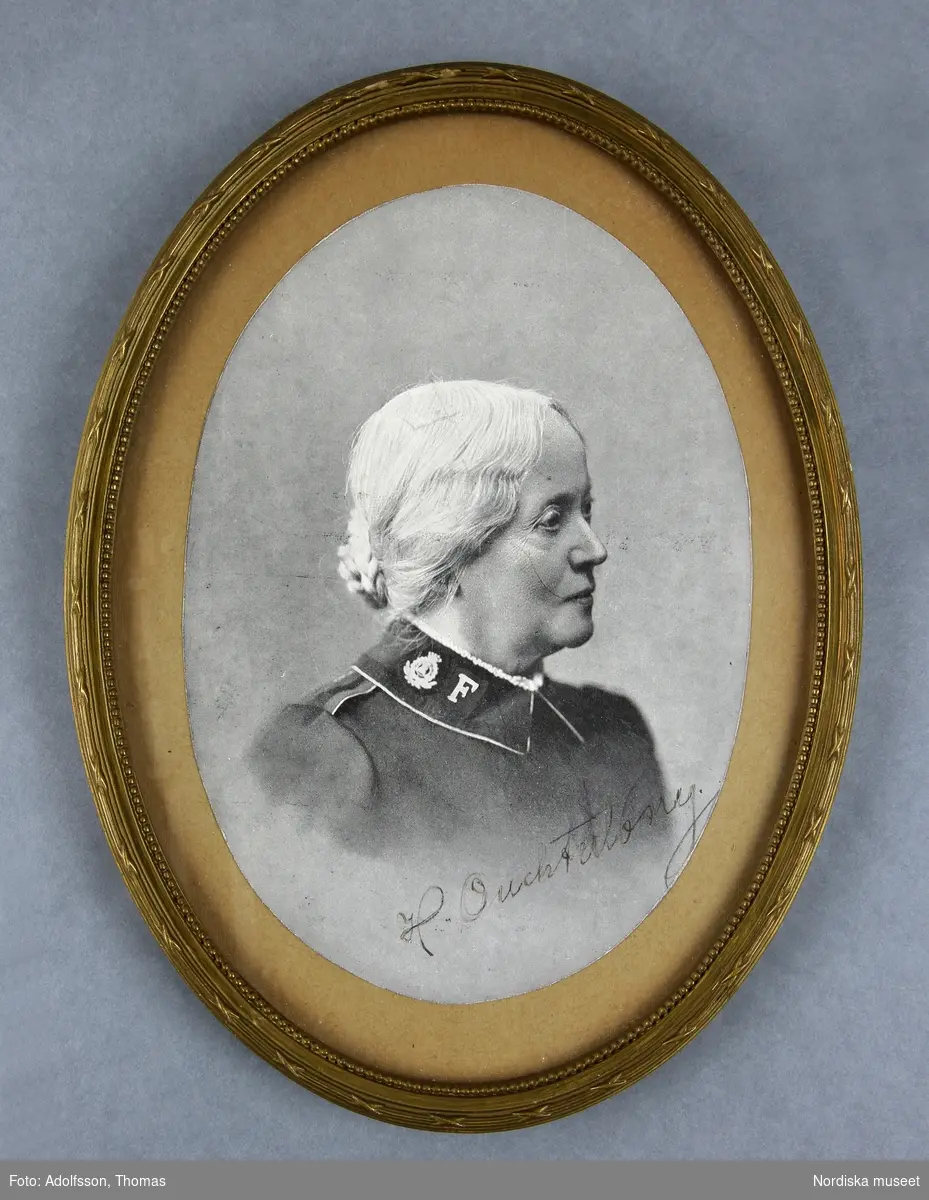 Porträtt av äldre dam iförd uniform. Bröstbild, närmast helprofil, vänd åt vänster.