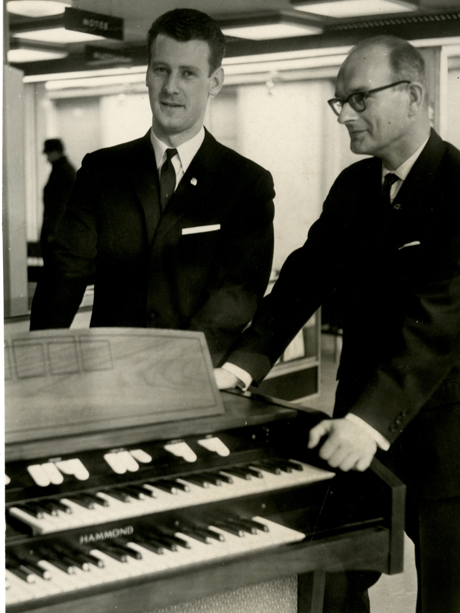 Fra Olaf T. Ranum's "kunstnervegg". bildet viser to menn ved et piano. Signert på baksiden.
Datert: 18.03.1967.