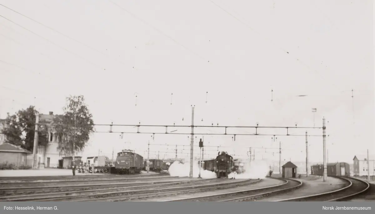 Hamar stasjon med elektrisk lokomotiv El 10 til venstre og damplokomotiv type 30b nr. 364 med persontog fra Oslo Ø til Otta, tog 307