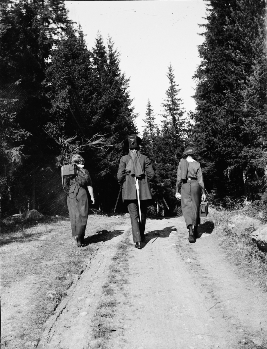 Syskonen Edhlund går bortåt på skogsväg, Östhammar, Uppland