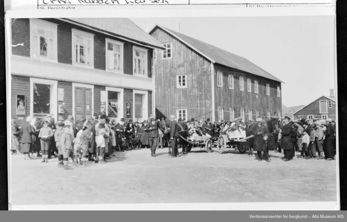 Begravelse i Kåfjord, stor folkemengde foran butikken. Kistene fraktes med hest og vogn.