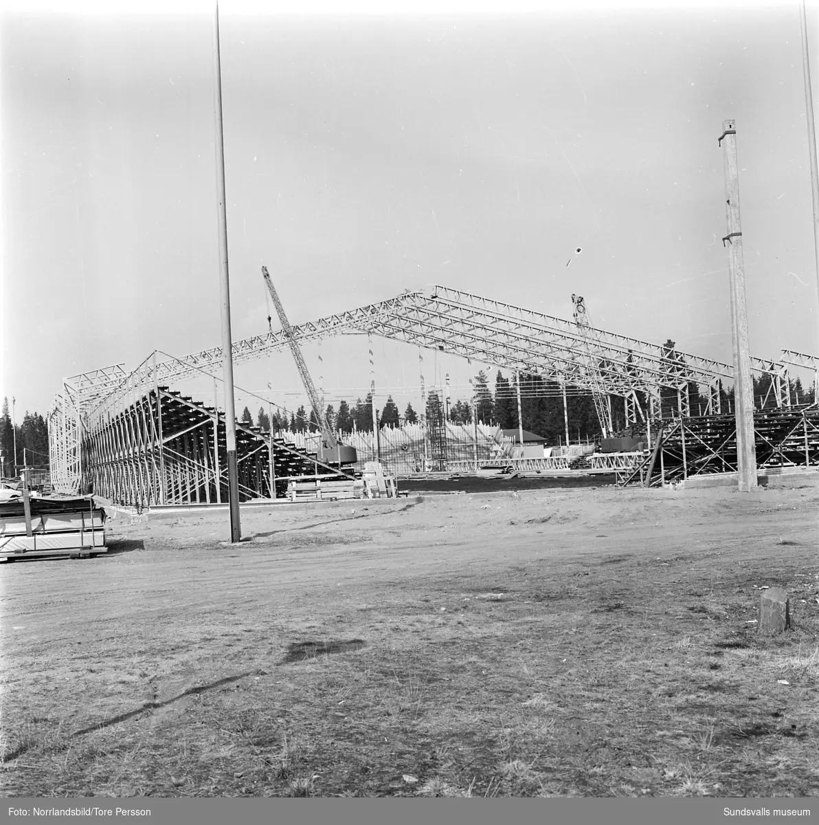 Bygget av isladan i Timrå, takstommen står klar. På bild två en av byggnadsarbetarna.