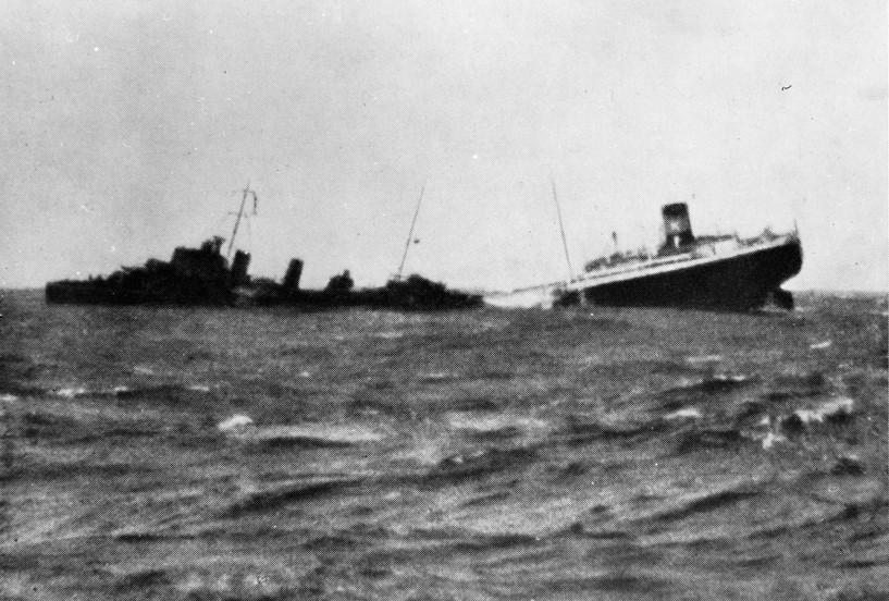 MT ARNE KJØDE (bygget i 1938) synker etter torpedotreff utenfor Hebridene, 15. november 1939. Til venstre et britisk eskorteskip som plukker opp overlevende.
