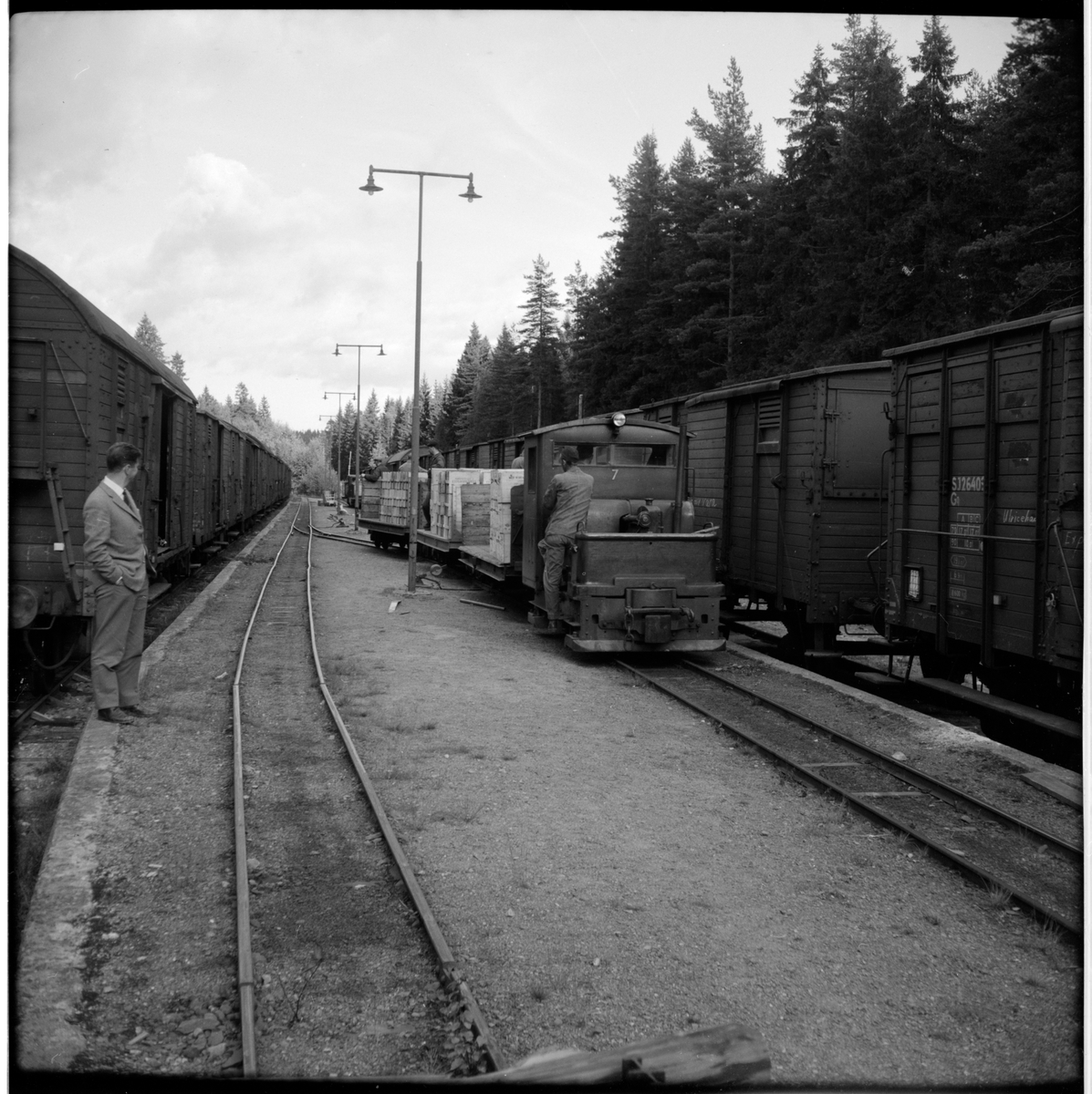 Lokomotor 7 för smalspår kopplad med tre lastade godsvagnar och personal på ekipaget. Statens Järnvägar, SJ Go26403 till vänster i bild.