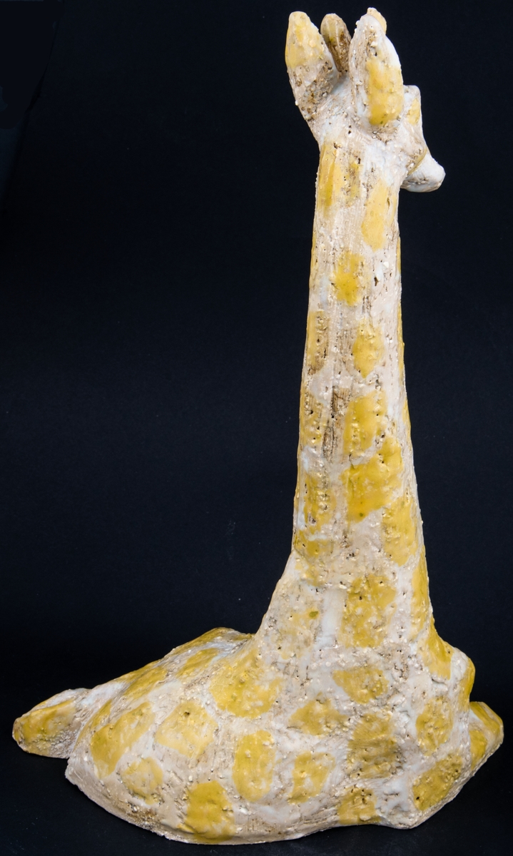 Modellerad figurin i stengods, ateljéproduktion, föreställande liggande giraff, formgiven av Lillemor Mannerheim.