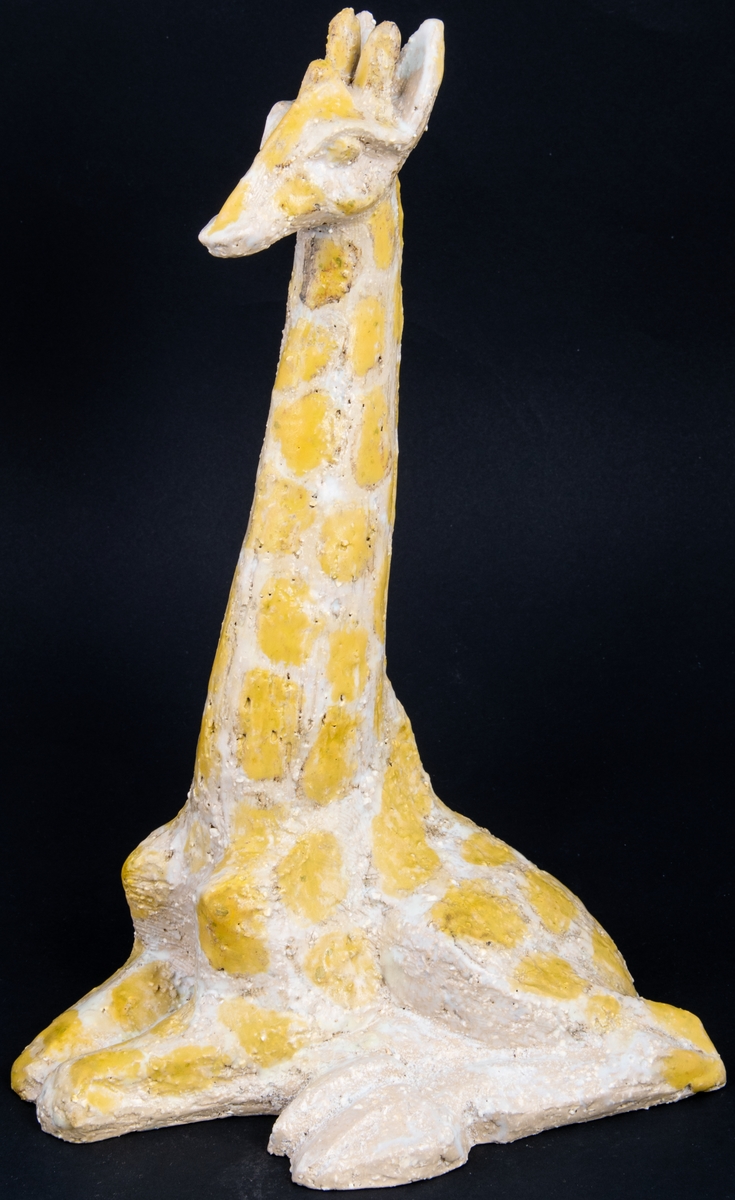 Modellerad figurin i stengods, ateljéproduktion, föreställande liggande giraff, formgiven av Lillemor Mannerheim.