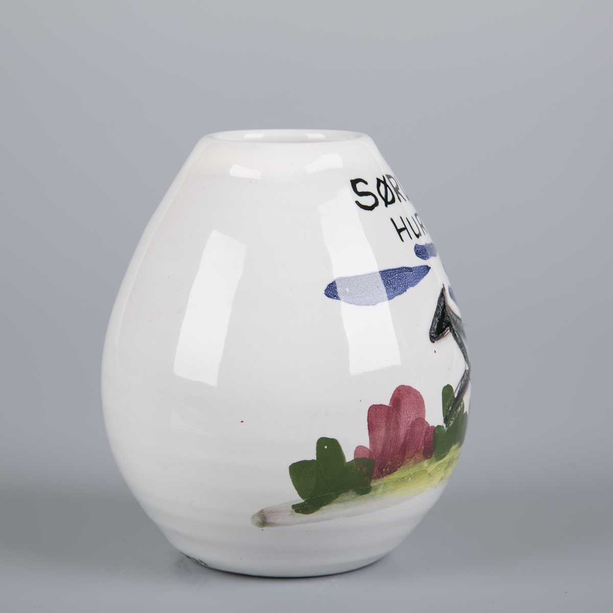 Liten eggeformet vase med tegning av hund som løper i landskap.