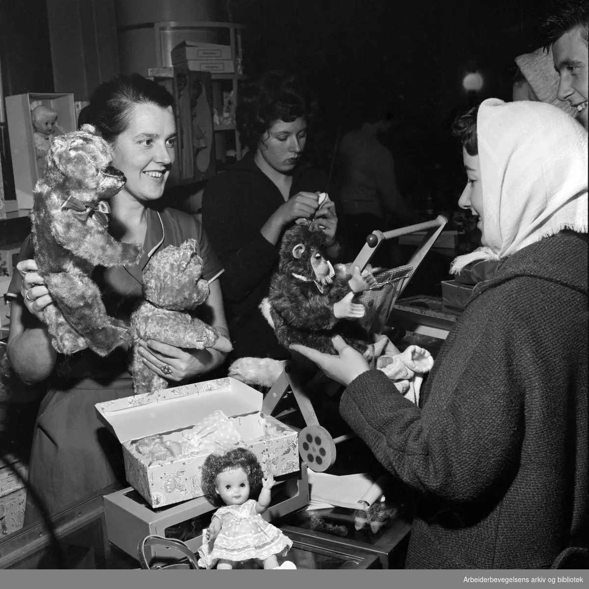 "Skal det være en teddybjørn så kanskje denne kunne friste, sier unge fru Østern som er ekstrahjelp i leketøysavdelingen i et stormagasin". Desember 1959.