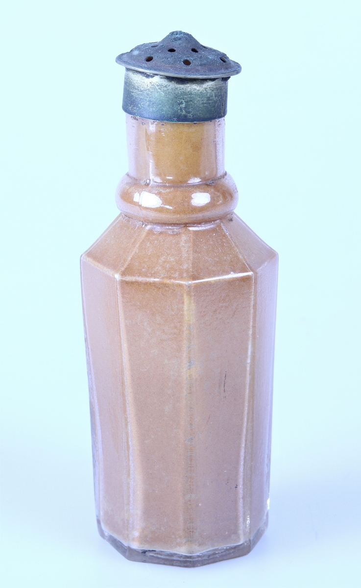 Åttekantet krydderflaske med strølokk av metall.