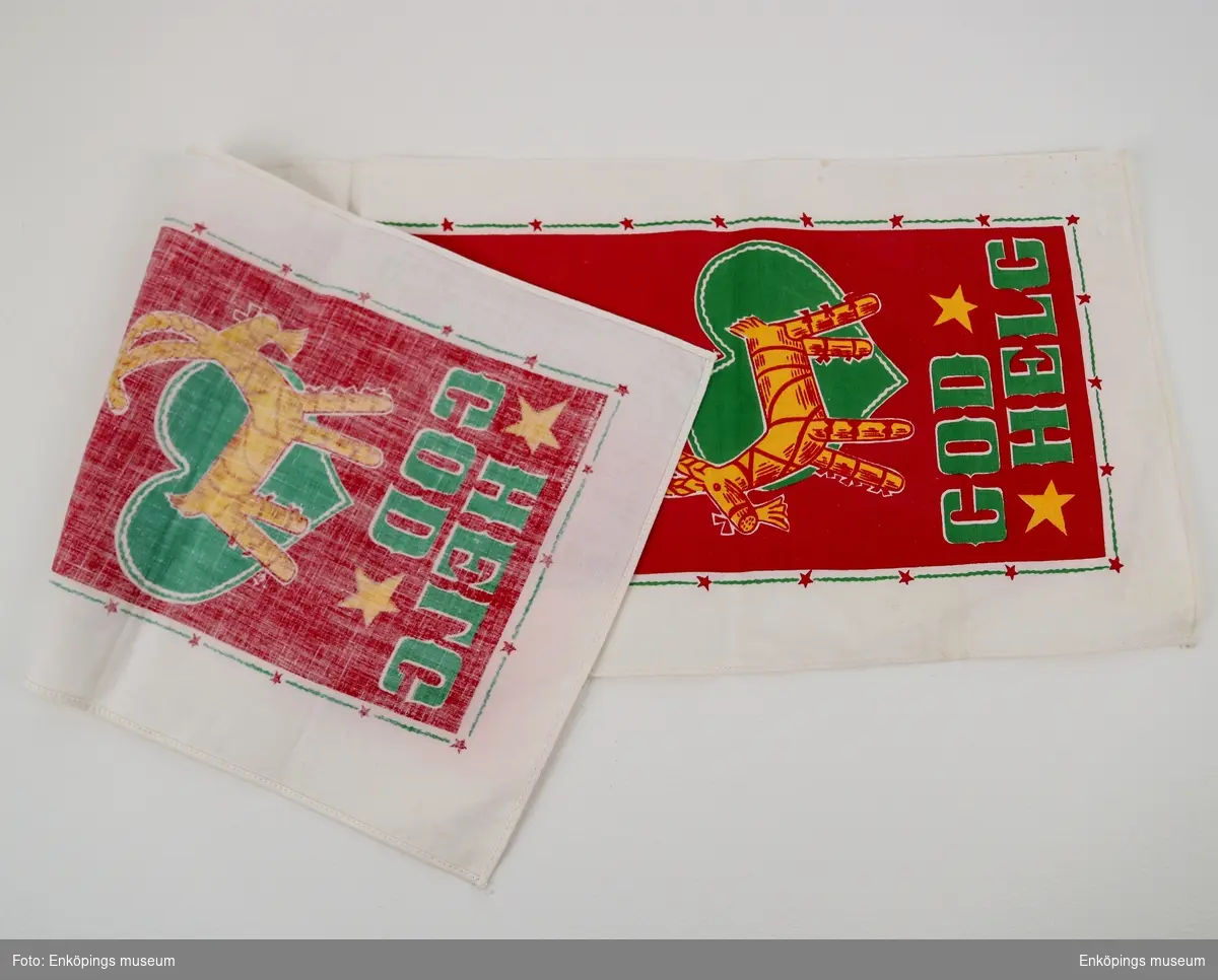 Jullöpare, mönster i gult, rött och grönt tryckt på bomullstyg. Motiv: 2 stycken "God Helg" och Julbockar, två klockor i mittpartiet.