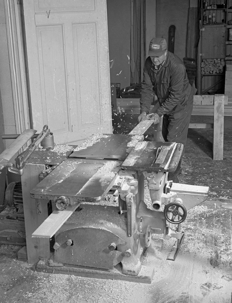 Bygging av fløterbåt (Flisa-båt) november 1984. Fra Glomma fellesfløtingsforenings båtbyggerverksted på Flisa i Åsnes kommune i Solør. Lars Bernhard Olastuen, høvling av bord, bruker maskin.